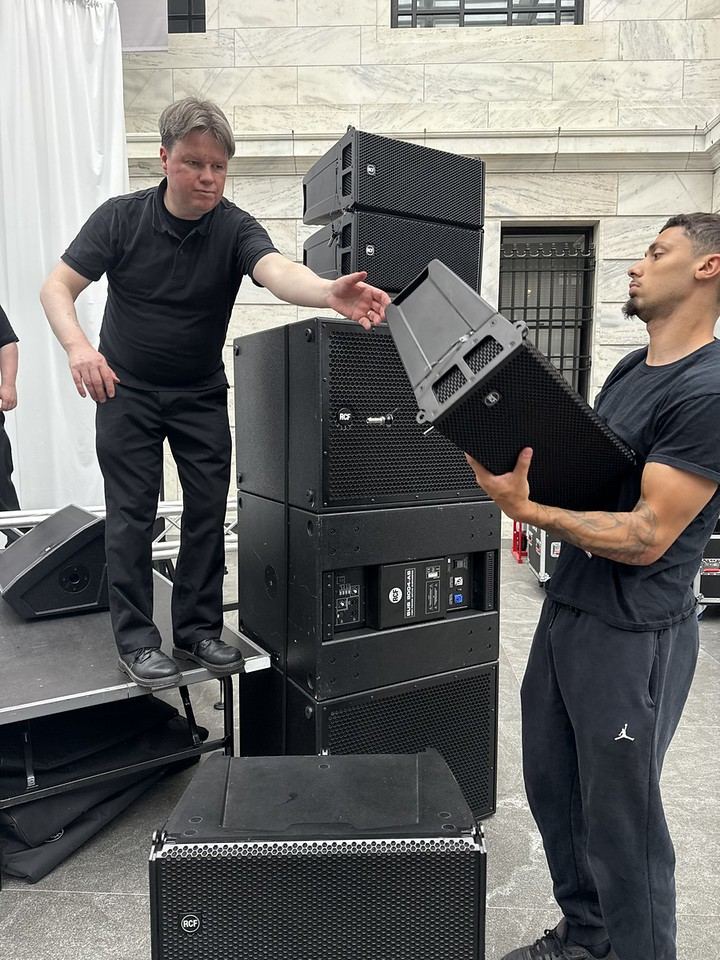 Two crew members assembling a flown RCF line array stack